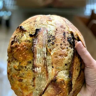 a hand holding a loaf of bread