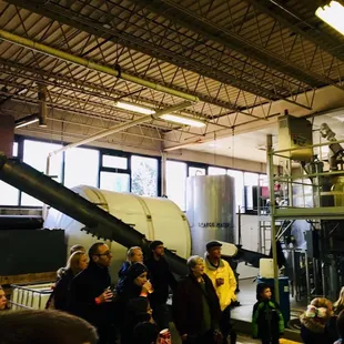 a group of people standing in a brewery