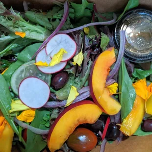 Organic field greens with peaches and edible flowers