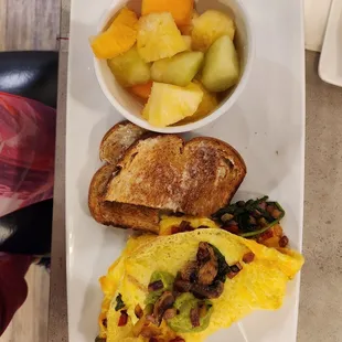 Veggie omelet, wheat toast, and fresh fruit cup