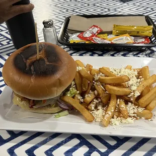 Burger with French fries and some type of cheese