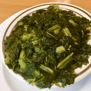 a plate of greens on a wooden table