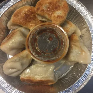 a plate of dumplings and dipping sauce