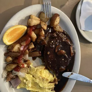 Hamburger steak with mushrooms,peppers,onion,potatoes and scrambled eggs