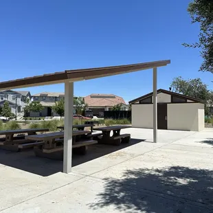 Covered picnic area with 4 tables and a barbecue grill
