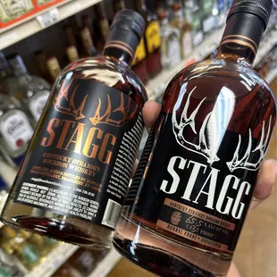a hand holding a bottle of stagg