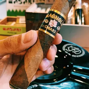 a hand holding a cigar