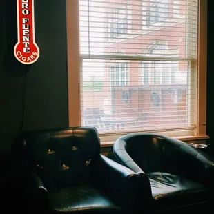 a living room with black leather furniture
