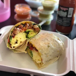 a breakfast burrito in a styrofoam container
