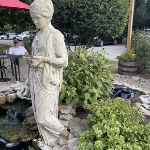 a statue of a woman holding a glass of wine