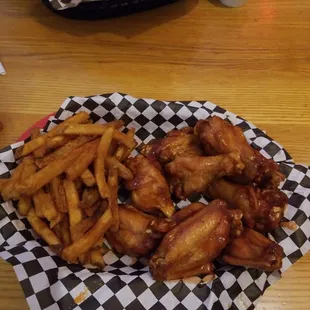 a basket of chicken wings and french fries