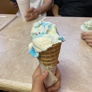 Two scoops of birthday cake in a waffle cone