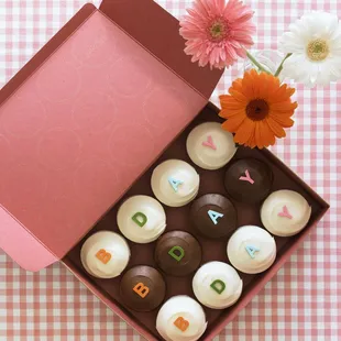 a box of chocolates with letters and flowers