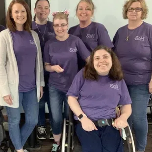 a group of people in purple shirts