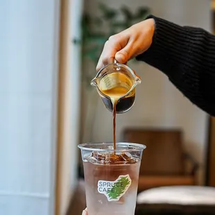 a person pouring coffee into a cup