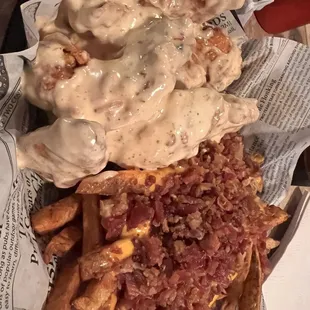 a plate of french fries with gravy and bacon