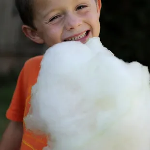 a young boy holding a cotton candy floss