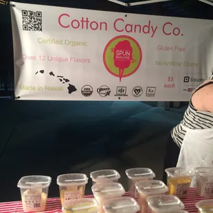 a woman standing in front of a table of cupcakes