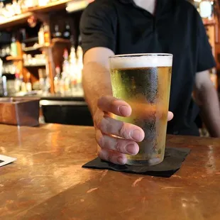 a man holding a pint of beer