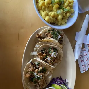 a plate of tacos and a bowl of macaroni and cheese