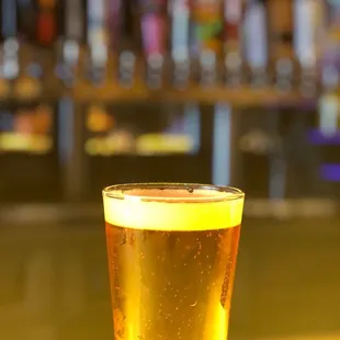 a glass of beer on a bar
