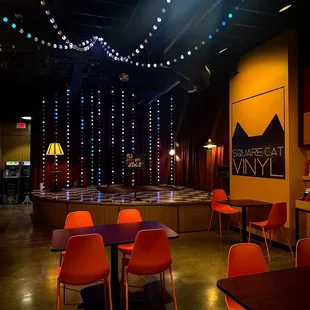 an empty stage with red chairs