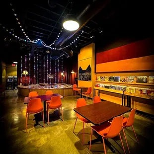 an empty restaurant with orange chairs
