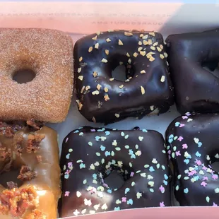 Cinnamon sugar, chocolate frosted with peanuts, chocolate frosted, maple bacon, chocolate frosted with sprinkles