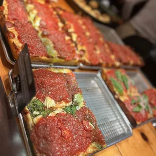 a variety of pizzas on pans