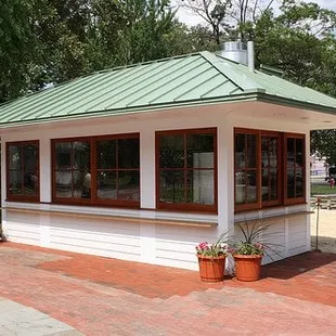 a small white building with a green roof