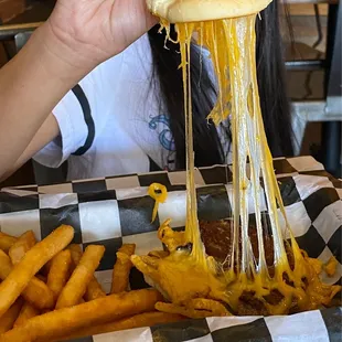 a woman eating a cheeseburger and fries