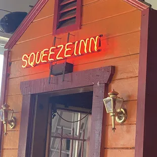 a neon sign for squeeze inn