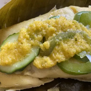Pastelle cooked in a banana leaf with mango and cucumber toppings
