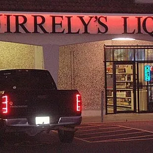 two trucks parked in front of a liquor store
