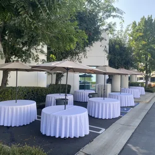 60" Round Tables with Tan Umbrellas.