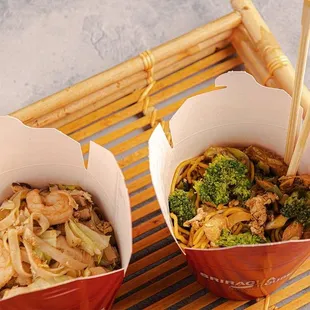 two take out boxes with noodles and broccoli