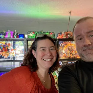 Patrons in front of several pinball machines.