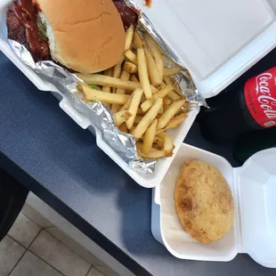 a burger and fries in a styrofoam container