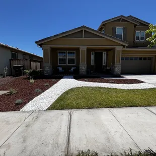 existing grass in the front, creation of walk way with bender board and  rock, and laying of weed preventer and woodchips.