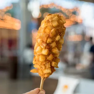 a close up of a hand holding a fried food item