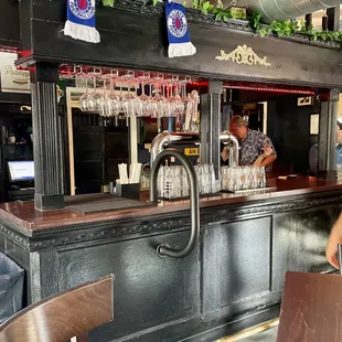 a bar with wine glasses on the counter