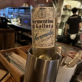 a hand holding a bottle of wine
