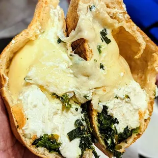 a hand holding a half eaten pizza