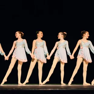 Lyrical dancers holding hands during performance