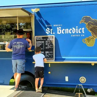 a man and a boy ordering coffee from a truck