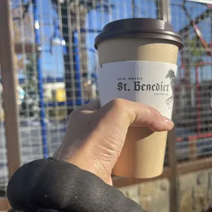 a hand holding a cup of coffee