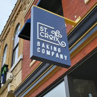 a blue sign hanging from the side of a building