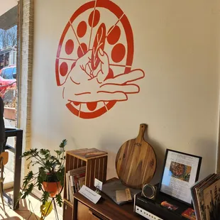 a pizza shop with a pizza on the wall