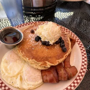 Butter pancakes with blueberries, eggs and bacon