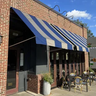 the outside of a restaurant with a blue and white awning